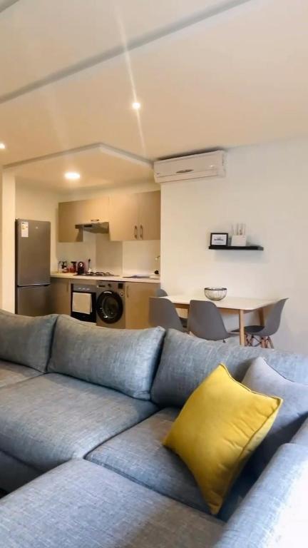 a living room with a blue couch with a yellow pillow at Studio de standing à maarif in Maarif