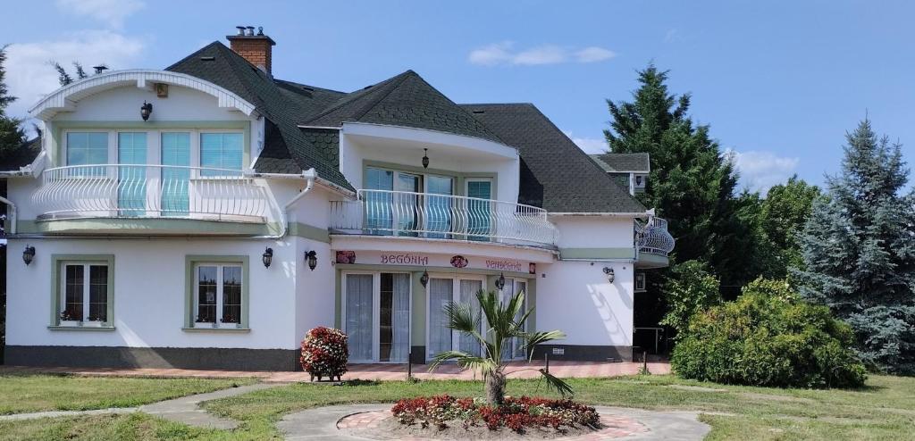 a large white house with a balcony at Begónia Vendégház in Szigetszentmiklós