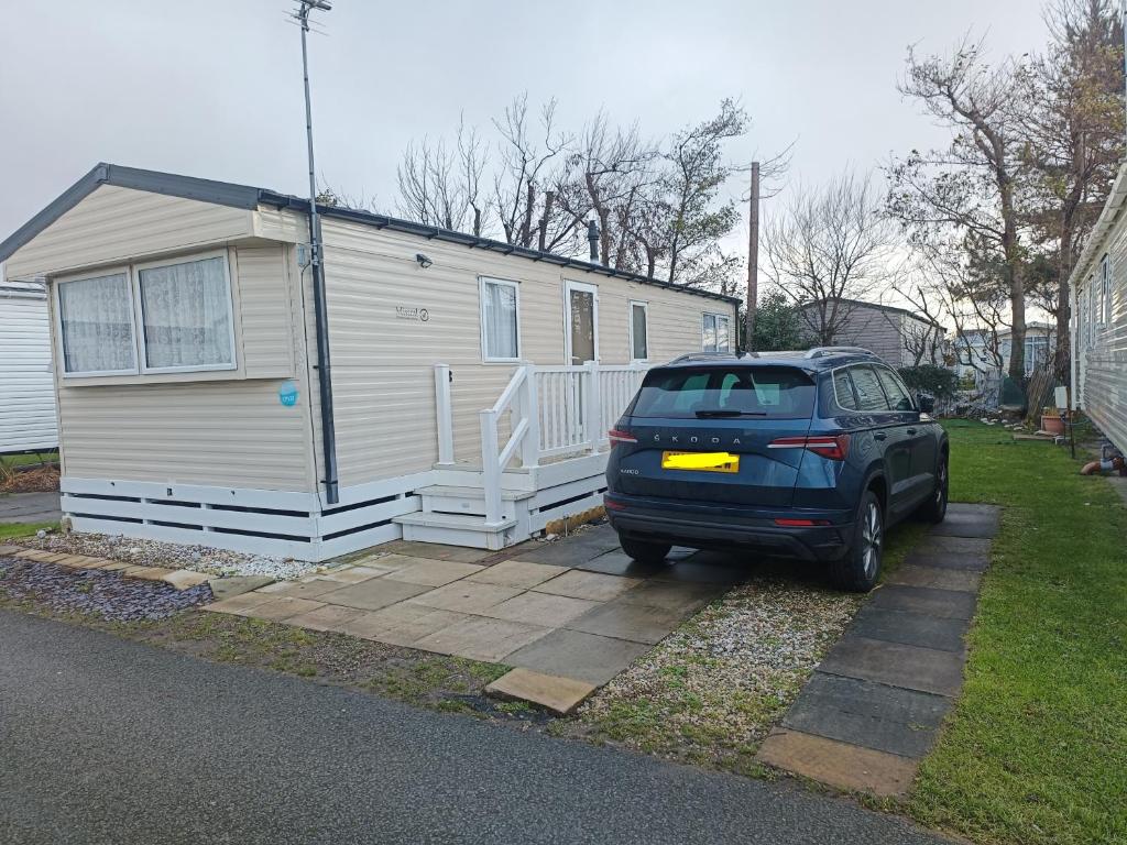 una macchina parcheggiata di fronte a una casetta di Ollys House a Prestatyn