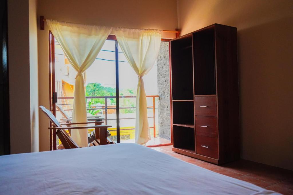 een slaapkamer met een bed en een groot raam bij Posada El Mágico in Mazunte