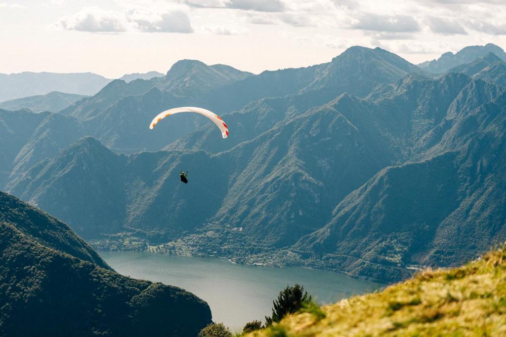 uma pessoa voando de parapente sobre um vale montanhoso em Casa Reiner em Bondone