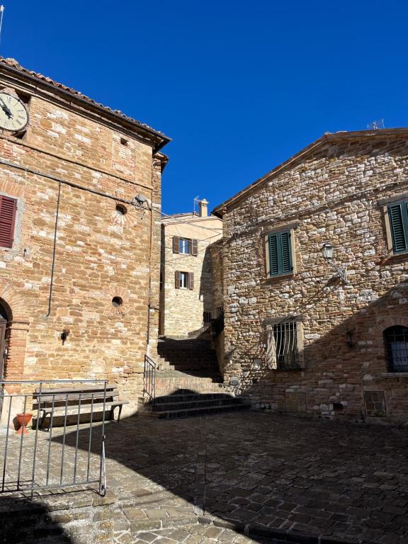 due edifici in pietra con una panchina di fronte di Mia Piccola Casina ad Arcevia