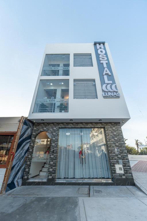 a tall building with a staircase in front of it at Hostal 3 Lunas in Paracas