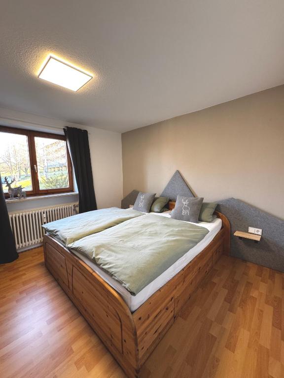 a bedroom with a large wooden bed in a room at FeWo Bergruh 922 im Ferienpark Oberallgäu in Missen-Wilhams