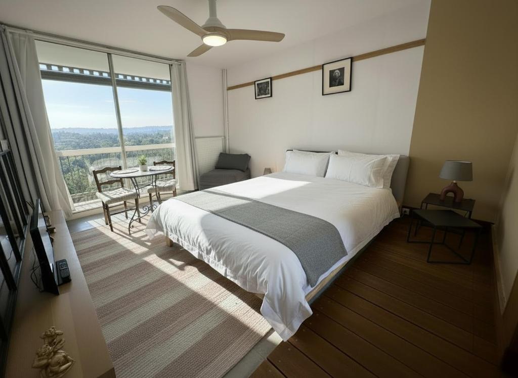 um quarto com uma cama grande e uma janela grande em Studio idéal pour Beauval em Montrichard