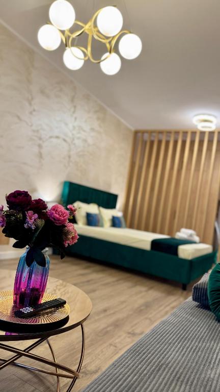 a living room with a couch and a table with flowers at SHoliday Sky Panoramic Apartment New Building Private Parking in Timişoara