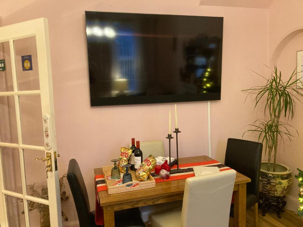 a dining room table with a television on the wall at Mountroyal Victorian Self Catering Apartment 2 in Belfast