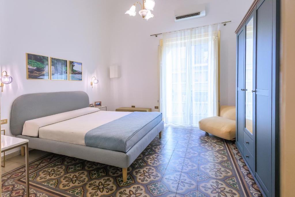 a bedroom with a bed and a large window at Vintage Rooms in Palermo