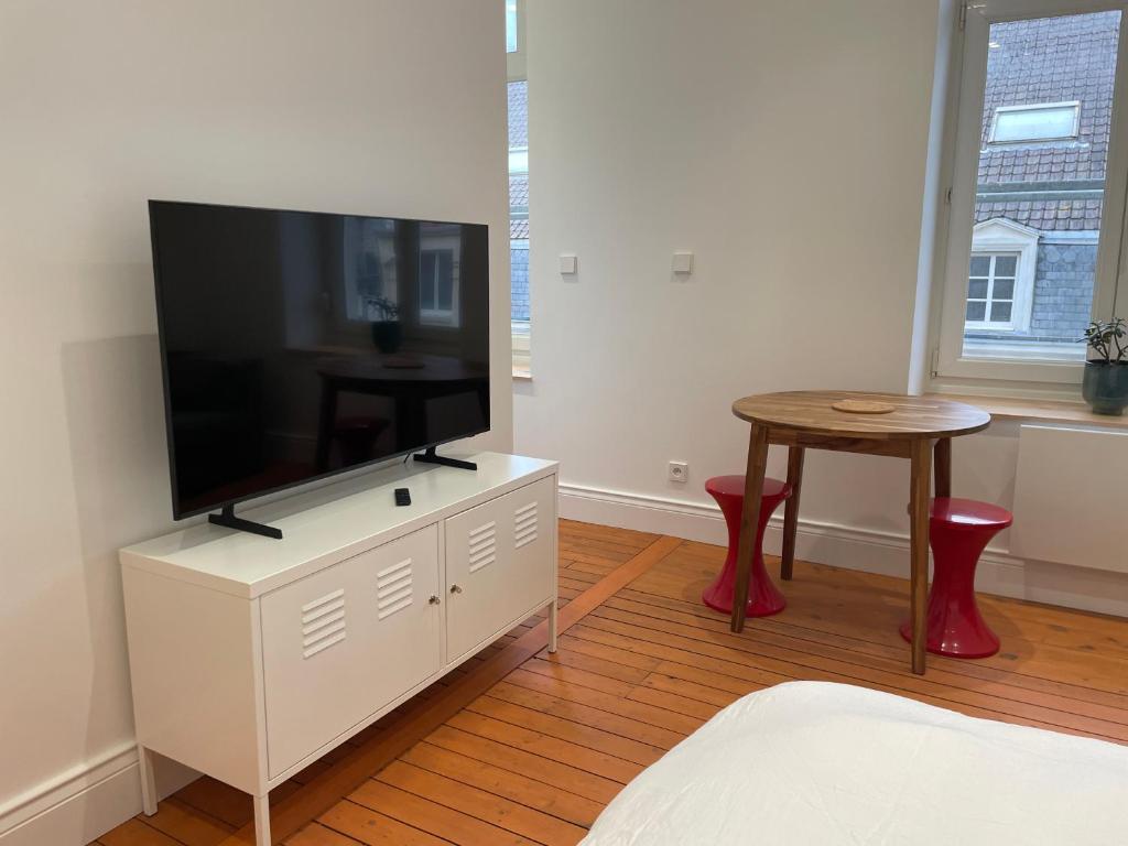 una sala de estar con TV de pantalla plana en un armario blanco en Studio La cabine, en Wimereux