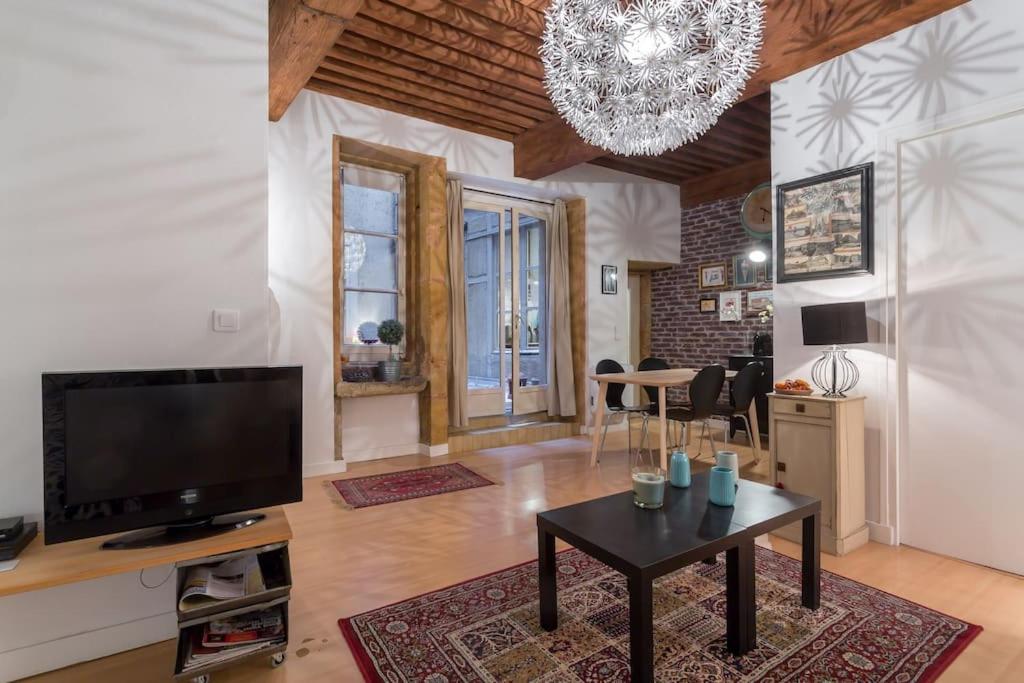 a living room with a tv and a table at Le 27 L in Lyon
