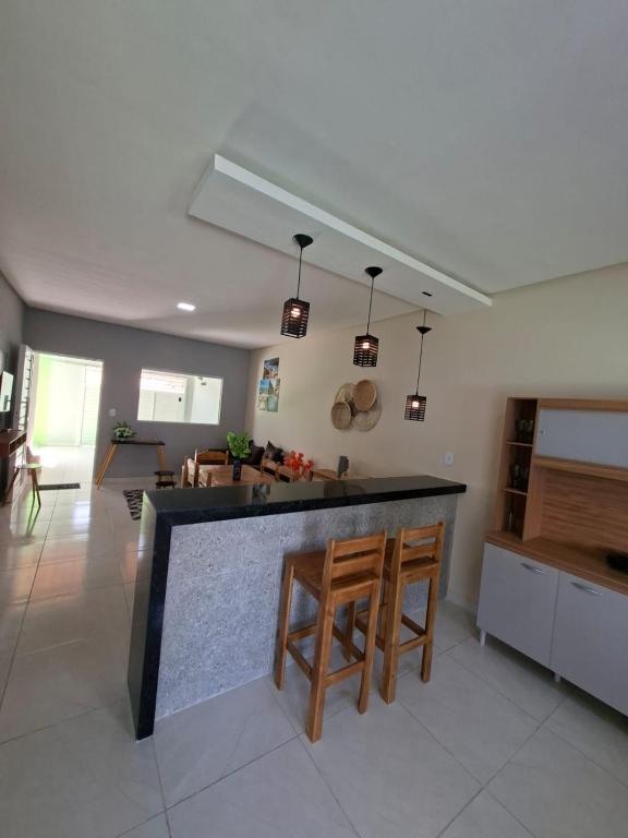 a kitchen with two chairs and a counter in a room at Casa completa de temporada- ReFÚGIO in Piranhas