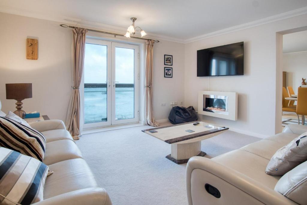 una sala de estar con un sofá y una mesa en 13 St Brides Bay View - 4 Bedroom - Broad Haven, en Broad Haven