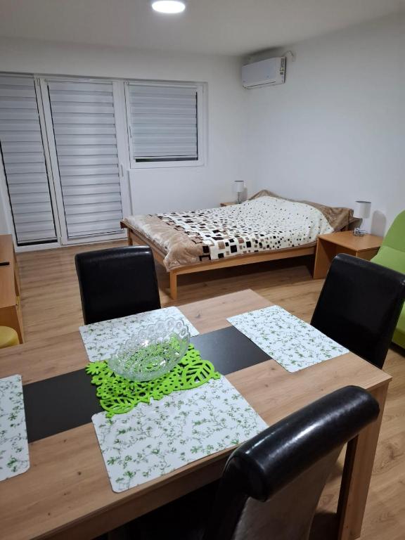 a dining room with a table and a bed at Apartmani Milićević in Vršac