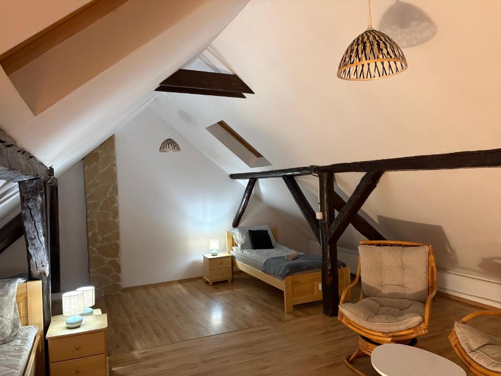 a living room with a bed and a chair at Dom w górach Zacisze lasu in Sucha Beskidzka