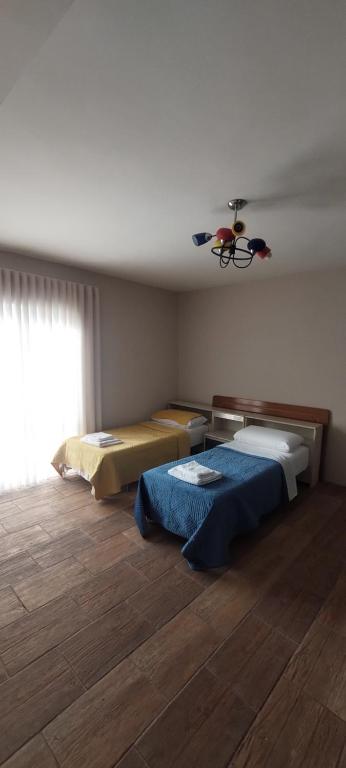 Dinamo Bed&Breakfast في إلباسان: غرفة نوم بسريرين في غرفة بها نافذة