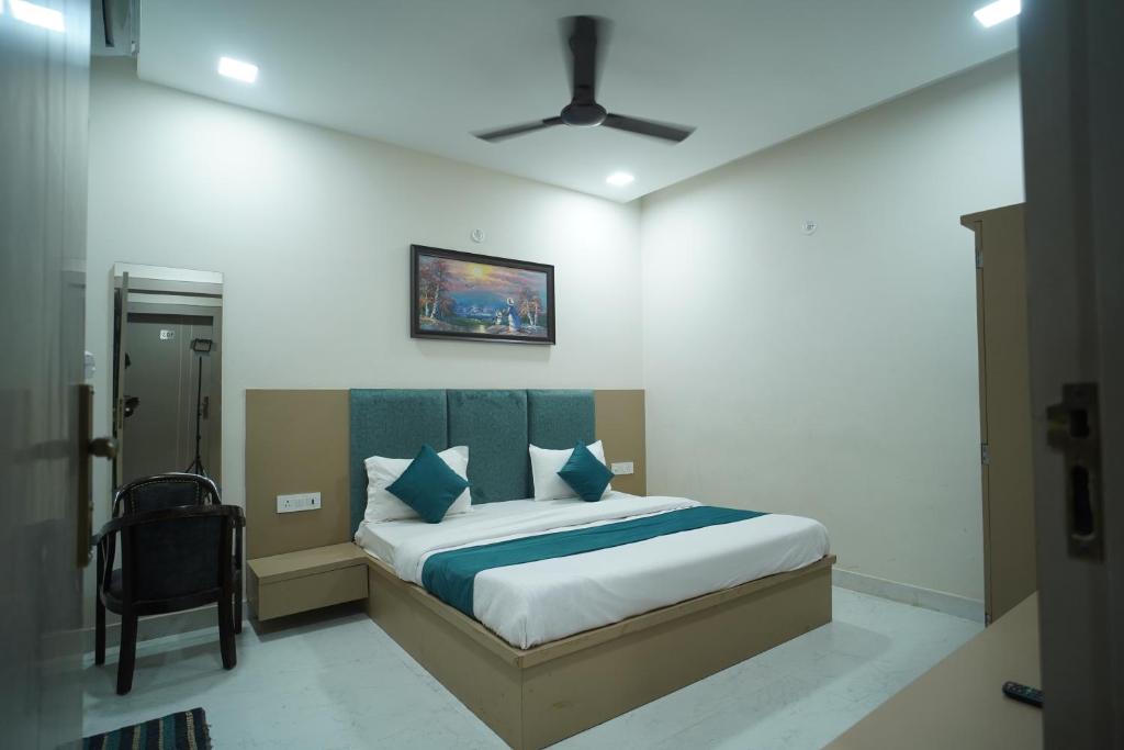 een slaapkamer met een bed met blauwe kussens bij Hotel Shri Radha Sneh 500 Mtrs From Shri Krishna Janma Bhumi Mathura in Mathura