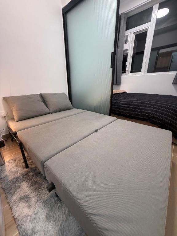 香港市中心九龍尖沙咀民宿公寓a في هونغ كونغ: غرفة نوم بها سريرين ومرآة