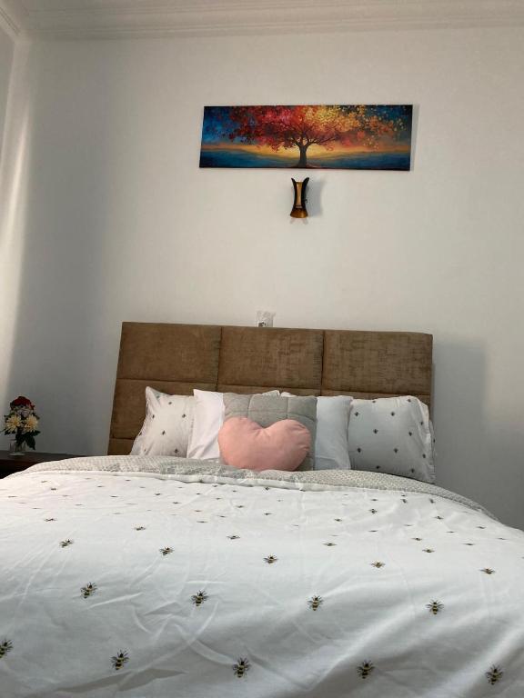 a bedroom with a bed with a painting on the wall at EdenRose Guest House in Kwabenya