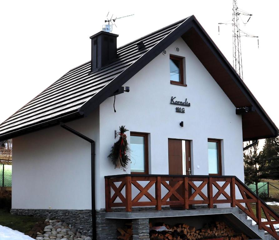 a small white house with a black roof at Domek Kornelia in Bańska Wyżna