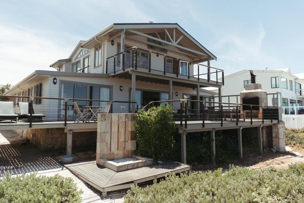 a large house with a porch and a balcony at Dune Rose Yzerfontein Villa in Yzerfontein