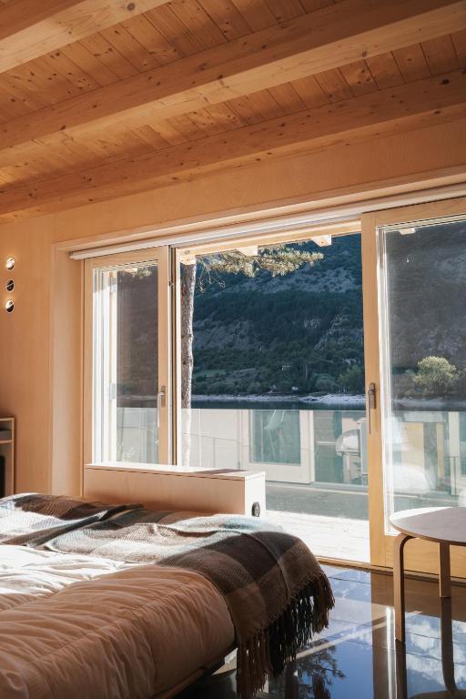 a bedroom with a bed and a large window at La Presentosa guest house in Villalago