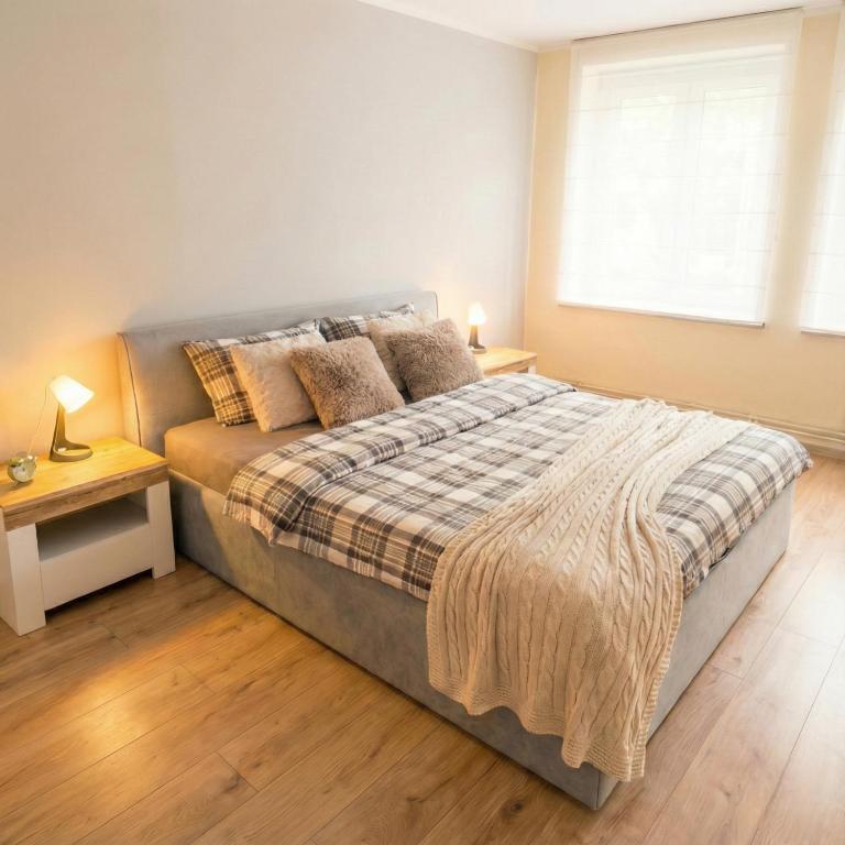 a bedroom with a large bed and a window at Apartament Słoneczny Węgorzewo 74m2 in Węgorzewo