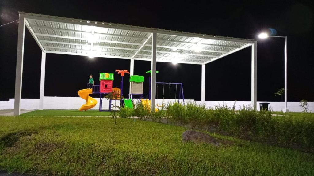 Een persoon speelt 's nachts op een speeltuin. bij Joseline House in San Miguel