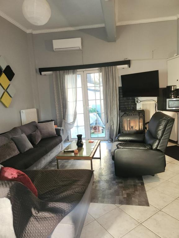 Una sala de estar con dos sofás y una chimenea. en jim villa, en Andravída