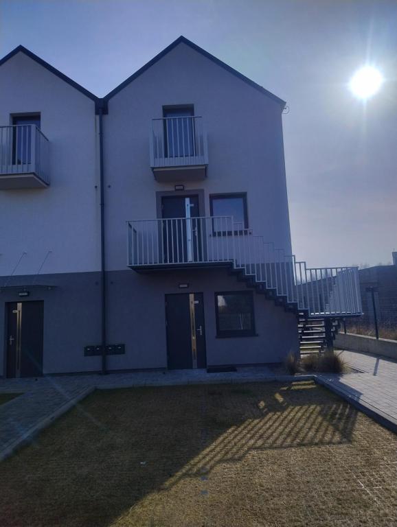 a white building with a staircase on the side of it at Ostoja we Władku in Władysławowo