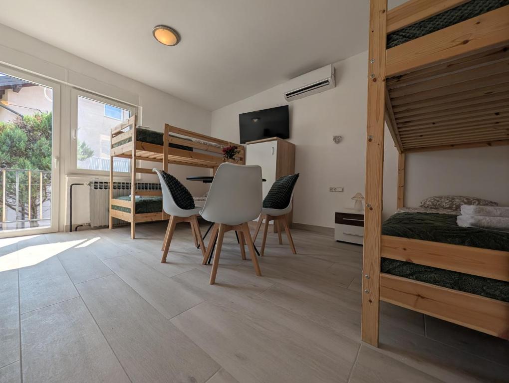 a bedroom with bunk beds and a table and chairs at Sesvete Studio 4 Four in Sesvete