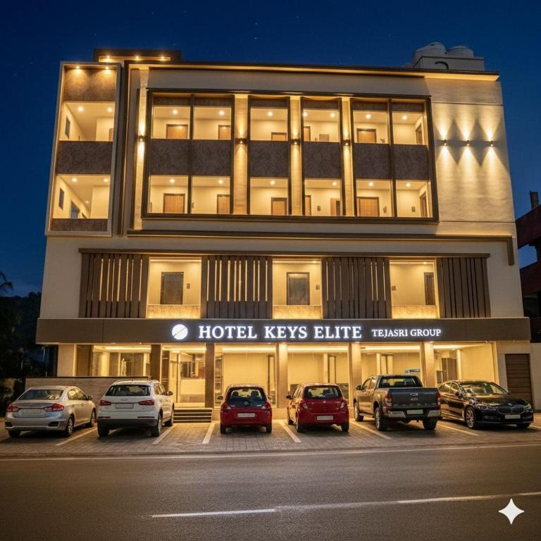 ein Gebäude mit auf einem Parkplatz abgestellten Autos in der Unterkunft Hotel Keys Elite in Vijayawāda