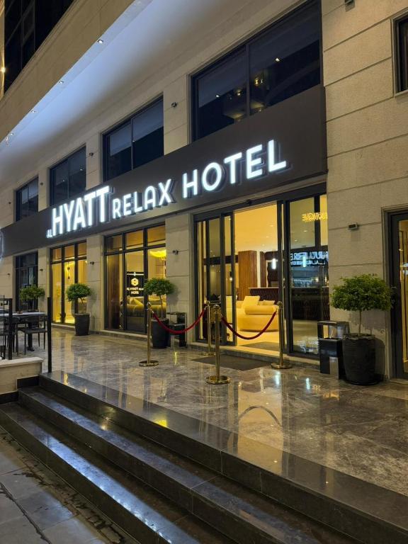 een hotelgebouw met een bord waarop staat: Kiwi Relax Hotel bij AL Hyatt Relax Hotel in Aqaba