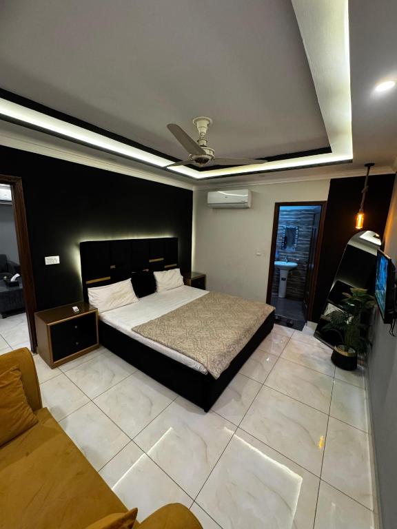 a bedroom with a bed and a couch at Stay Prime Apartments in Lahore