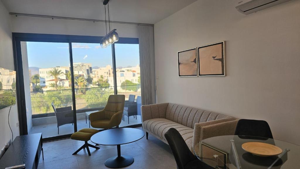 a living room with a couch and chairs and a window at STAY Engomi Gem 2 in İncirli