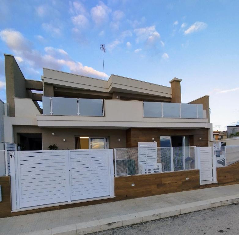 uma casa com portas brancas e uma cerca em Garden Relax Suites em Ispica