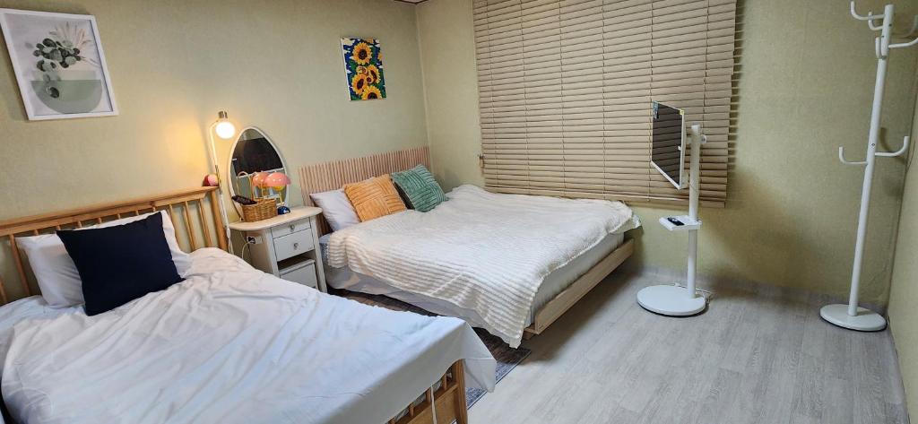 a bedroom with two beds and a window at 베델하우스 Bethel House in Seoul