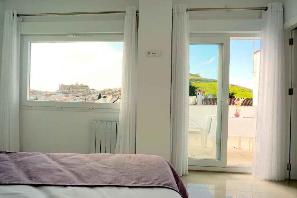 Un dormitorio con una cama y una ventana grande. en Principado de Aracena I, en Aracena
