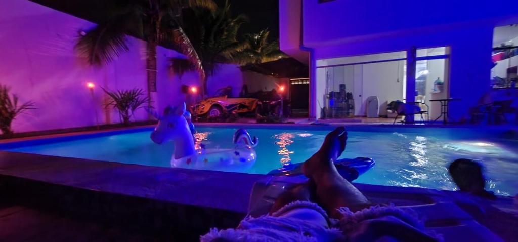 a person laying down in a swimming pool at night at Casa de playa Iberico in Caleta Grau
