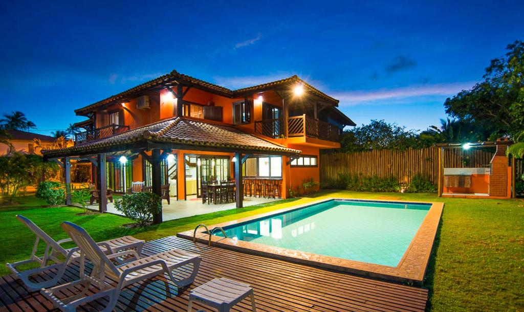 a house with a swimming pool in the yard at Casa Andrea in Praia do Forte