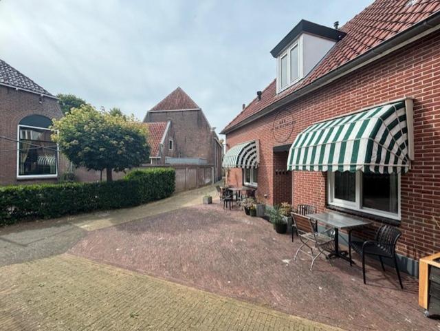 a patio with a table and chairs next to a building at In de Kathoek in Blokzijl