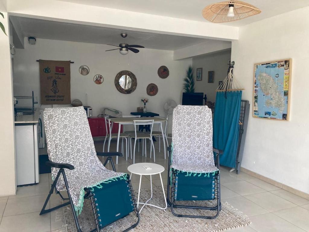uma sala de estar com duas cadeiras e uma mesa em Appartement 2 personnes em Rivière-Salée