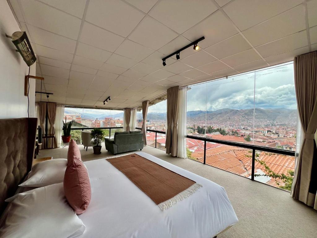 a bedroom with a large bed and a large window at Casa Encuentro San Blas in Cusco