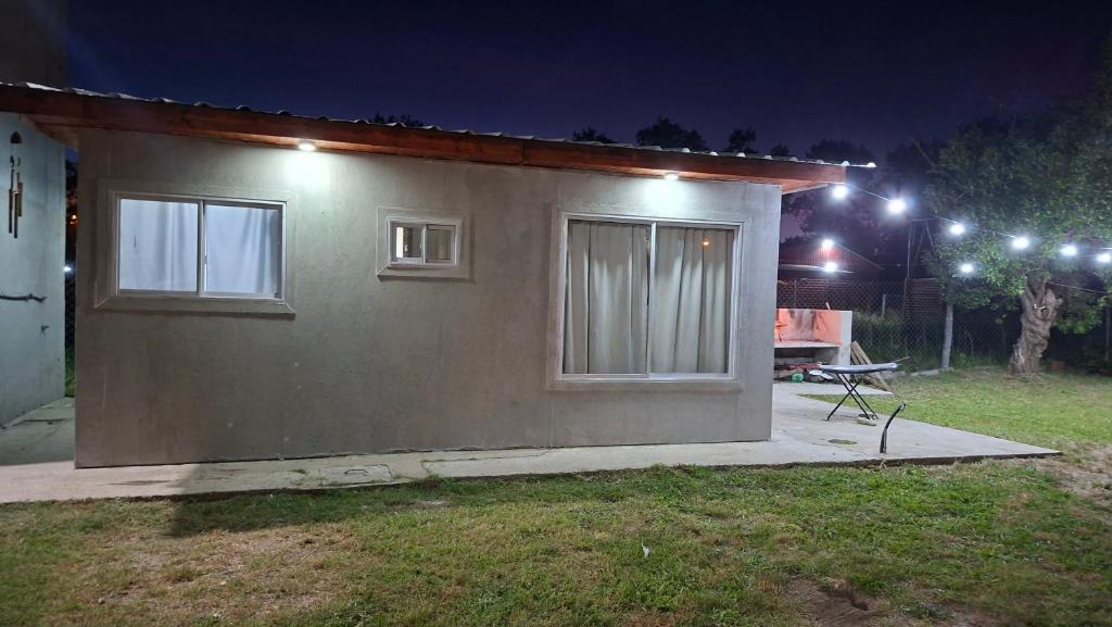 una piccola casa con due finestre e un tavolo in un cortile di El Campito 2 a Necochea