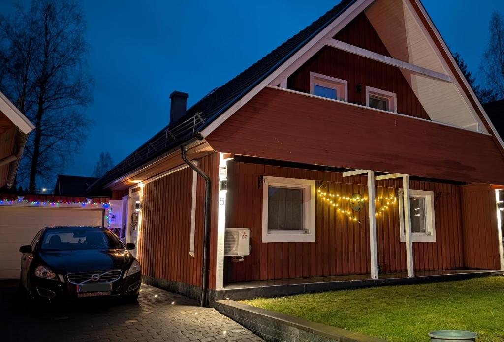 ein vor einem Haus mit Weihnachtsbeleuchtung geparktes Auto in der Unterkunft Svedjan Escape Villa in Hedemora