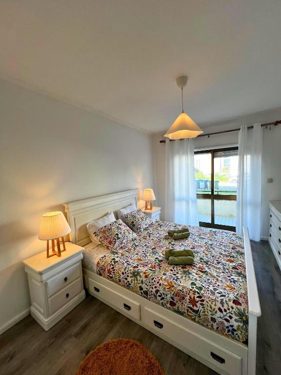 a bedroom with a bed and two lamps and a window at Naval Beach Apartment in Azurara