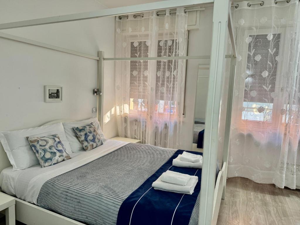 een witte slaapkamer met een bed met handdoeken erop bij Residenza Borgo Trento SUNDAY in Verona