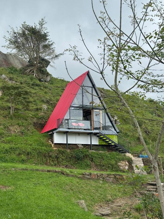 a small house with a red roof on a hill at Ebenezer Chalet in San Antonio del Tequendama