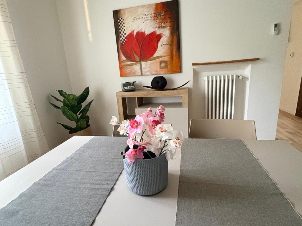 een vaas met roze bloemen op een tafel bij Oltre le mura in Montefalco