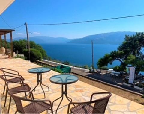 un patio con sedie e tavoli e vista sull'acqua di Vero's Seaview Studio a Lefki
