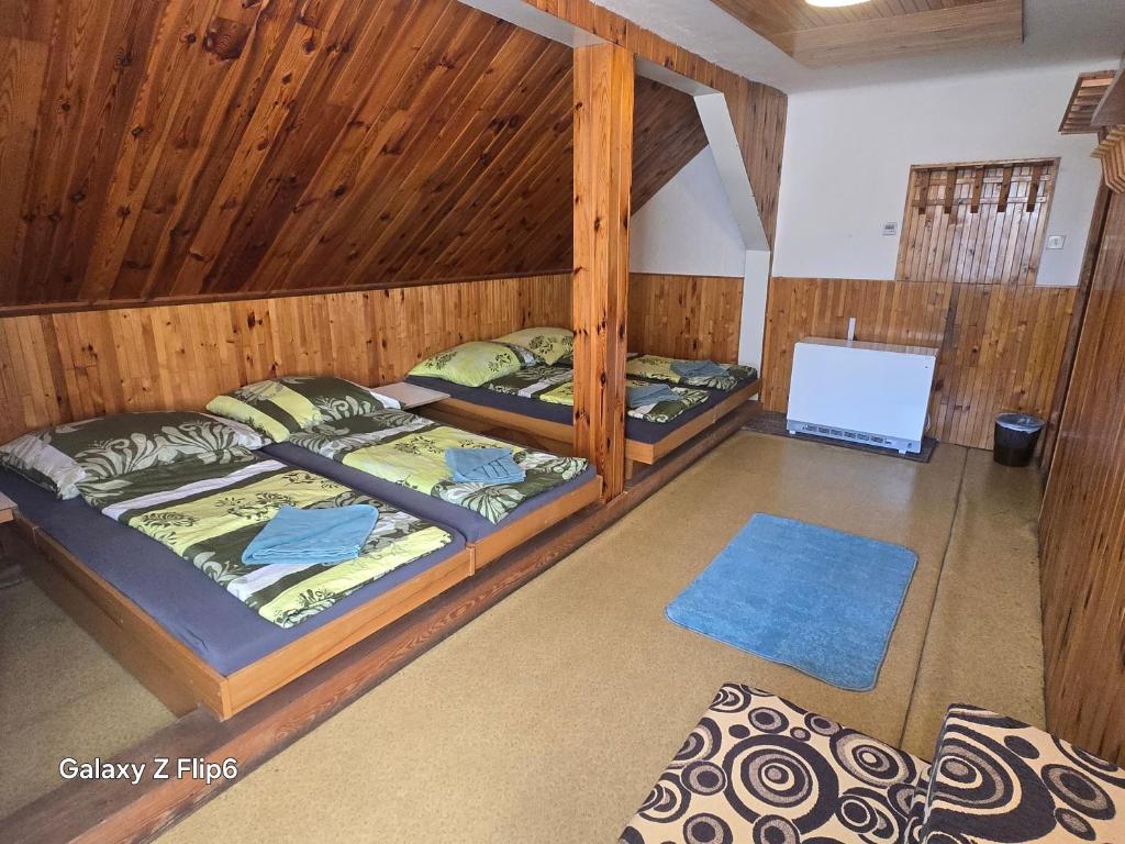 two bunk beds in a room with wooden walls at Horská CHATA U ŠPIČÁKU in Josefuv dul